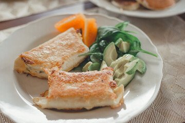 Tortillas with cheese, avocado, herbs and tomato.