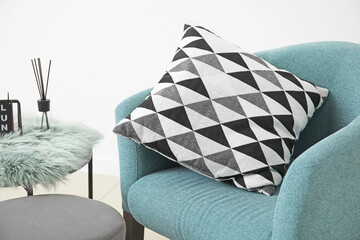 Stylish armchair with pillow in room
