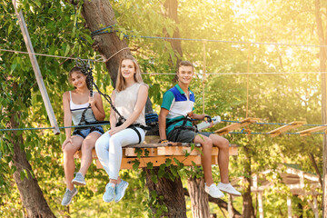 Naklejka na ściany i meble Teenagers climbing in adventure park