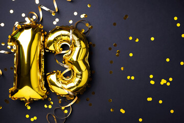 Gold foil balloon number, digit thirteen. Birthday greeting card, inscription 13. Anniversary celebration. Banner. Stylish golden numeral, light bokeh, glitter, black background. Numerical digit