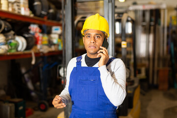 Head of construction store talking on mobile phone in a warehouse
