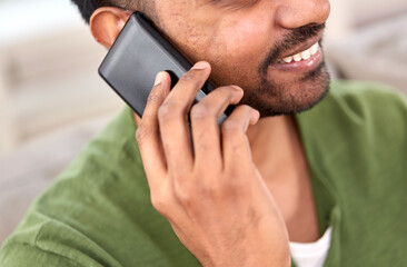 technology, communication and people concept - close up of happy smiling indian man calling on smartphone