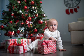 A baby toddler near a Christmas tree
