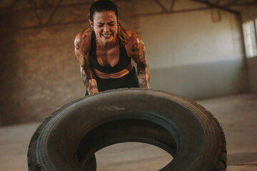 Obraz na płótnie Canvas Tough woman doing tire flip workout