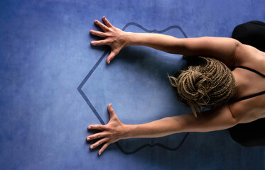 Young athletic woman doing breathing exercises, and a relaxing pose. Child's pose. Horizontal photography. Health and yoga concept.