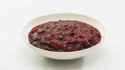 Fresh cooked homemade delicious cranberry sauce close up  in a bowl on kitchen table