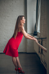 Woman wearing a red dress training her dance skills