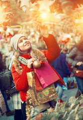 Young positive girl shopping decorations on traditional Christmas market in Spain