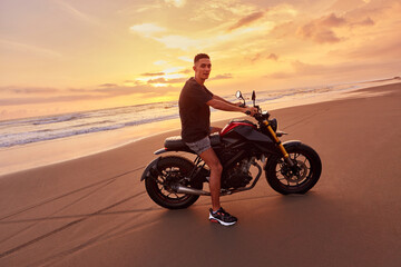 Man And Motorcycle On Ocean Beach At Beautiful Tropical Sunset. Handsome Biker On Motorbike On Sandy Coast In Bali, Indonesia.
