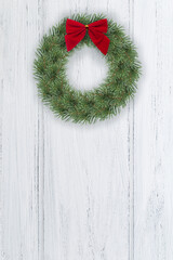 Christmas wreath on door. Xmas background, home decoration on white wooden door. Vertical format with copy space