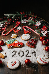 Christmas gingerbread cookies with Christmas decorations on wooden background. Traditional Christmas baking.