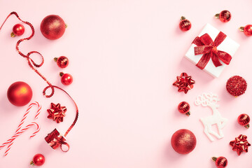 Christmas composition. Christmas red decorations on pastel pink background. Flat lay, top view, copy space