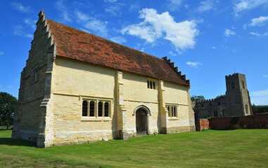 Fototapeta na wymiar Willington Church, and Stables with blue sky and clouds.