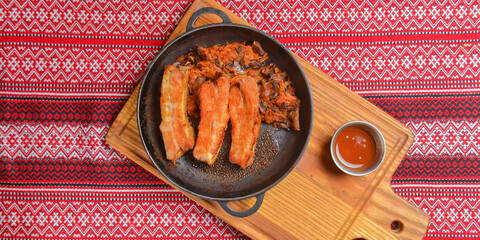 Delicious dinner and clean eating concept from above. Fried meat in a pan, on vintage background flat-lay.