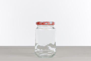 Tarro de cristal para conservas vacío en la mesa blanca