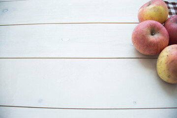 Apples in basket on brown wooden background