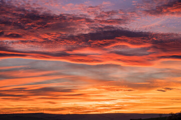 Fototapeta na wymiar Intensiv gefärbter bewölkter Himmel bei romantischem Sonnenuntergang