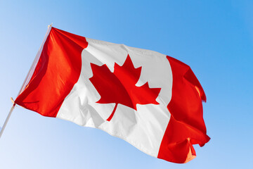 Flag of Canada waving against blue sky