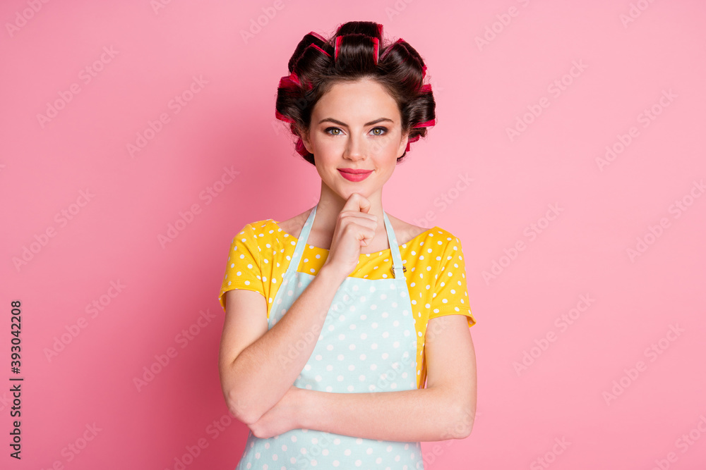 Poster Portrait of minded girl maid touch hands chin plan ponder solution wear hair rollers isolated on pink color background