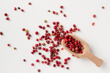red pepper peas spilled out of the spoon on a white background