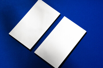 Two stacks of blank businesscards on blue background