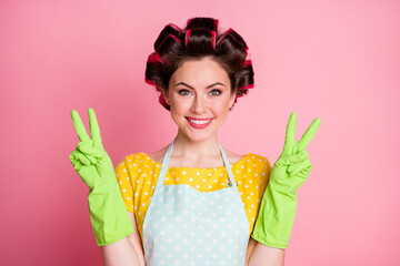 Portrait of positive girl make v-sign rubber gloves wear yellow dotted t-shirt isolated on pastel...