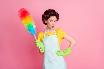 Portrait of her she attractive cheery brown-haired housemaid holding fluffy duster pout lips room service isolated on pink pastel color background