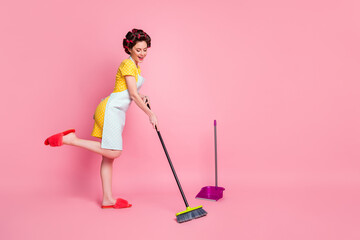 Full length body size view of pretty cheerful housemaid maid sweeping dirt dust dustpan dancing isolated on pink color background