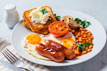 English breakfast with sausages, beans, fried eggs, toast, mushrooms and tomatoes in white plate. English breakfast concept.
