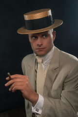 Man wearing boater hat and suit smoking cigar.