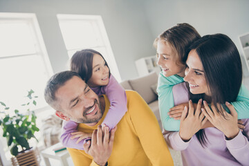 Photo of big family four people foster parents hold piggy back adopted kids wear colorful pullover...