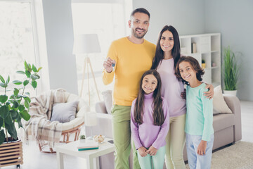 Fototapeta premium Photo of full family four people embrace dad hold show keys wear colorful pullover trousers in living room indoors