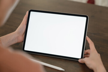 Mock up of woman hand holding digital tablet and touching blank screen.