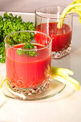 Freshly prepared tomato juice with celery leaves in a glass Cup is on the table. The concept of healthy food. It is an element of vegetarianism, keto diet, paleo diet
