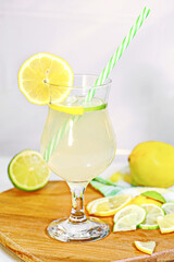 Refreshment Summer drink. Lemonade with ice in fancy glass with straw, there are lemons and a half near glass. concept of relaxing during the heat in the bar.