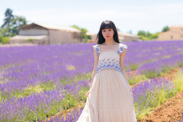 Asian women in white retro long dress standing in Provence lavender field in summer