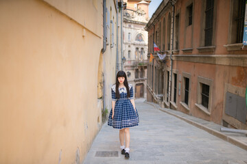Asian women in retro blue long dress walking in the street of an old French town,Chinese girl traveling in Europe