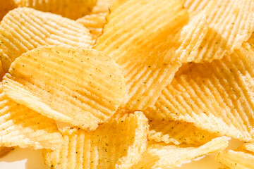 Background corrugated golden chips with texture. Potato chips is snack, ready to eat and fat food or junk food. Horizontal. Top view.