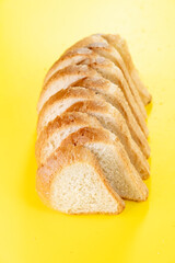 Sliced white bread on yellow background, top view