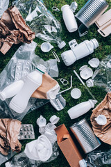 Food plastic packaging, trash on green moss background after picnic in forest. Top view. Copy space. Recycling plastic. Environmental pollution, ecology concept. Reuse garbage, recycle, plastic free.