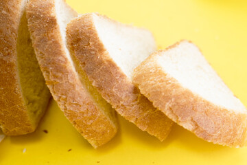 Sliced white bread on yellow background, top view
