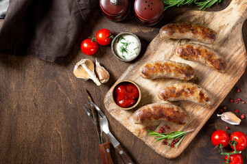 Fried sausages. Grilled sausages with spices on a wooden serving Board. Delicious meat sausages	