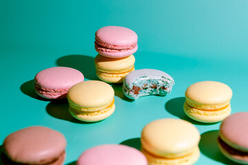 Mixed of sweet and colorful macarons  on a blue background with shadow.