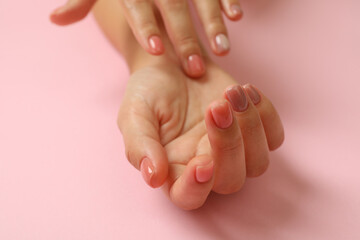 Cute female hands on pink background, close up