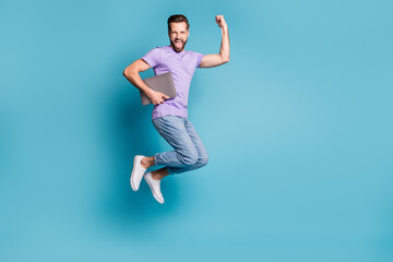 Fototapeta premium Full length body size photo of jumping freelancer with laptop gesturing like winner isolated on vibrant blue color background