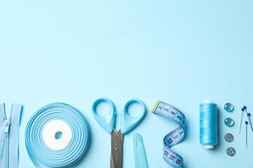 Blue sewing supplies on blue background, top view