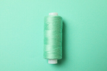 Sewing thread on mint background, space for text