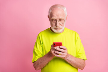 Photo of serious concentrated aged guy typing message wear lime clothing isolated on pink color background