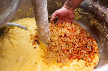 preparation of the typical Italian Christmas cake panettone, the candies are poured into the dough