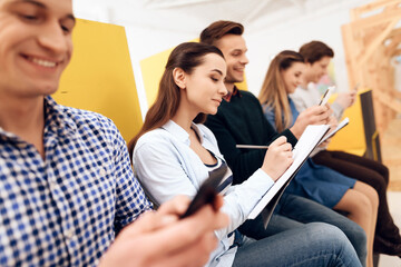 A man smiles while looking at the phone.